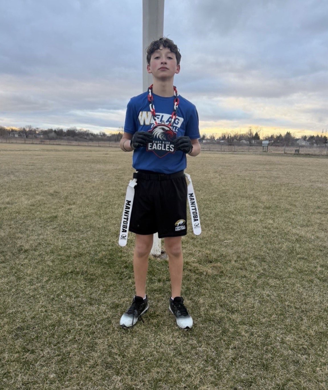 Royals player holding the Royals medal on the outdoor field