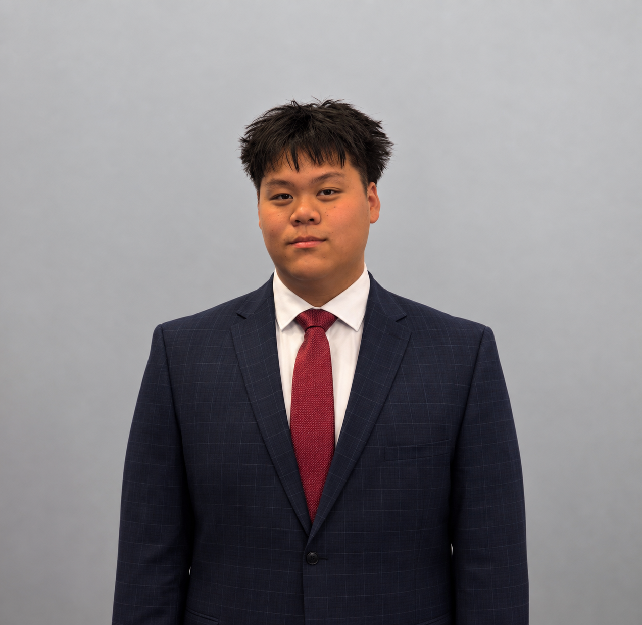Kevin Dang, Royals FFC coach, in a navy suit with a red tie